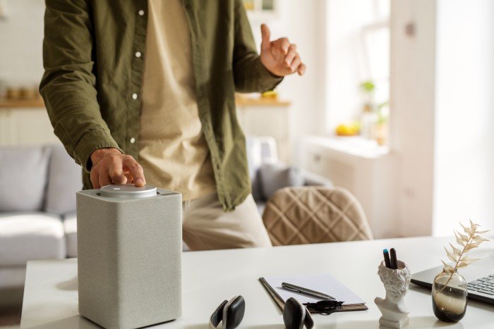 Man using a modern Bluetooth speaker designed by the best customized Bluetooth speaker manufacturer in Delhi.